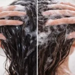 Pessoa lavando o cabelo com shampoo antirresíduo realizando limpeza profunda nos fios e couro cabeludo