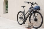 Bicicleta urbana com capacete, cadeado e acessórios sobre fundo claro