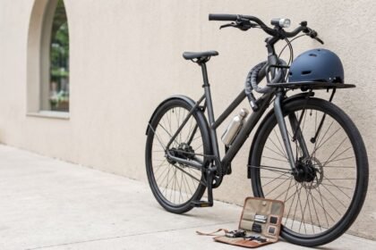 Bicicleta urbana com capacete, cadeado e acessórios sobre fundo claro